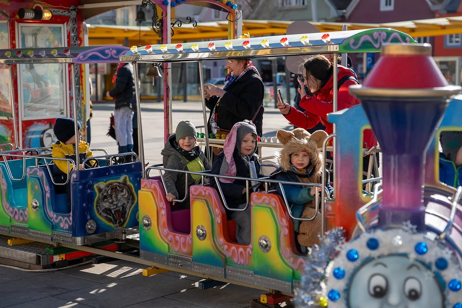 Ein kleiner Zug mit Kindern auf einem großen Platz