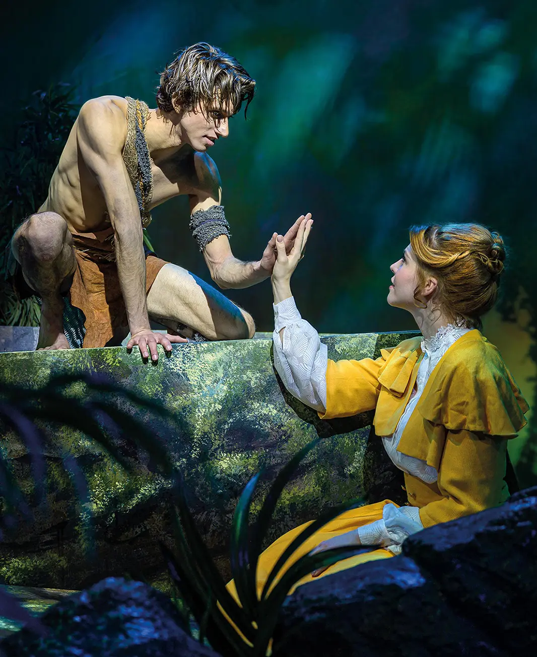 Ein Mann im Lendenschurz und eine Frau im Kleid in einer Dschungelkulisse