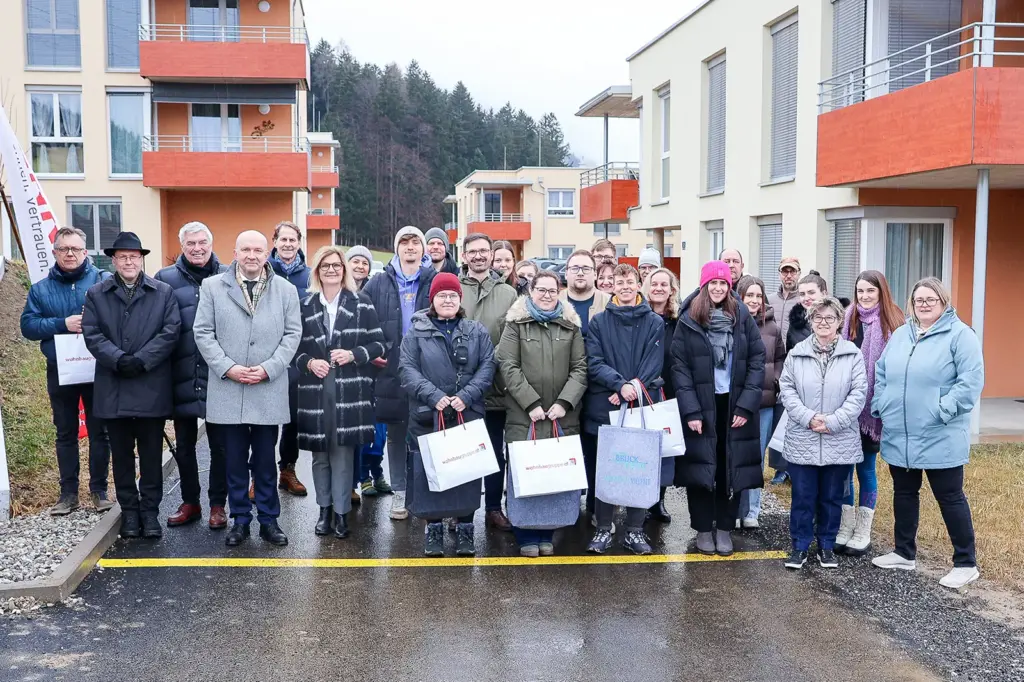Eine Gruppe von Personen auf der Straße vor einer neuen Wohnsiedlung