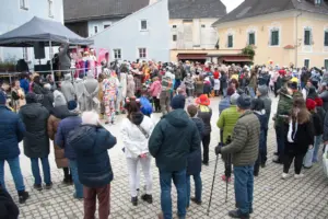 Verkleidete Menschen beim Faschingsumzug mit Besuchern.