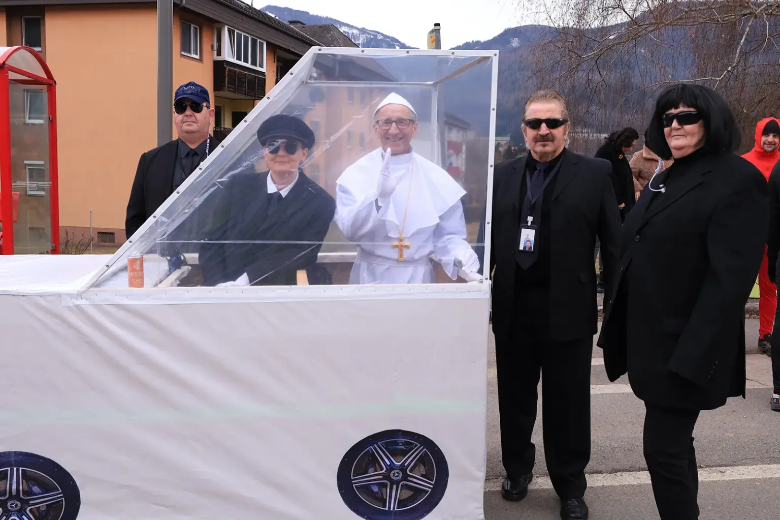 Ein als Papst verkleideter Mann mit verkleideten Bodyguards.