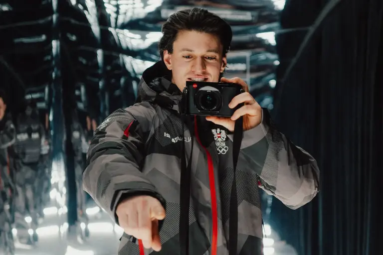 Ein Mann steht mit einer Kamera in der Hand vor einem Spiegel.