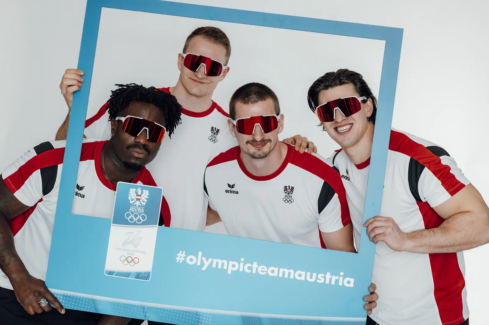 Vier Männer stehen nebeneinander, jeder hat eine Sonnenbrille auf.