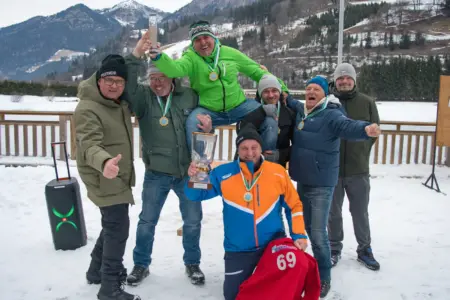 Eine Gruppe von Männern mit einem Pokal auf der Eisbahn