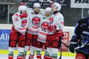 Vier Eishockeyspieler jubeln gemeinsam auf dem Eis.
