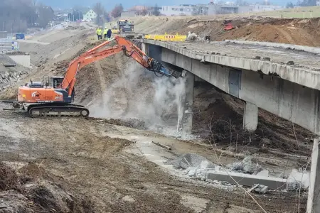Ein Bagger trägt eine Brücke ab