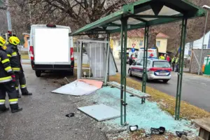 Feuerwehrleute vor einem weißen Lieferwagen und einem beschädigten Wartehäuschen