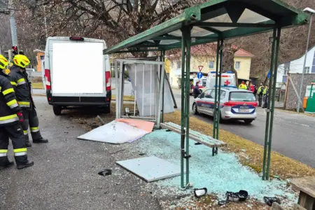 Feuerwehrleute vor einem weißen Lieferwagen und einem beschädigten Wartehäuschen