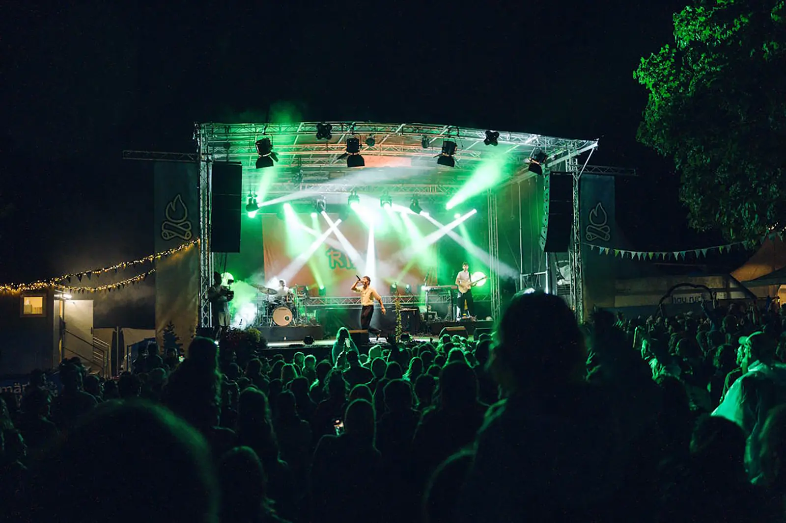 Eine Band auf einer Bühne mit vielen Zuschauern
