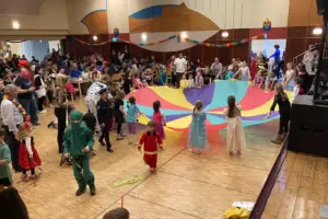 Gelungener Kindermaskenball in Kindberg Viele Kinder in Kostümen spielen in einem großen Saal