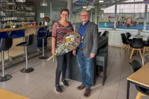 Ein Mann und eine Frau mit Blumenstrauß in einem Gastrolokal