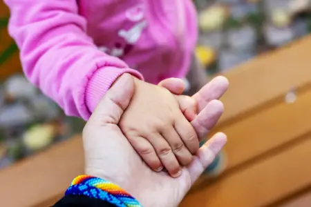 Die Hand eines Kleinkindes liegt in der Hand eines Erwachsenen