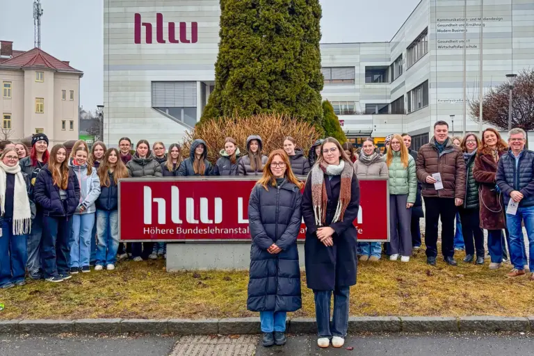 Eine große Gruppe junger Personen vor einem Schulgebäude
