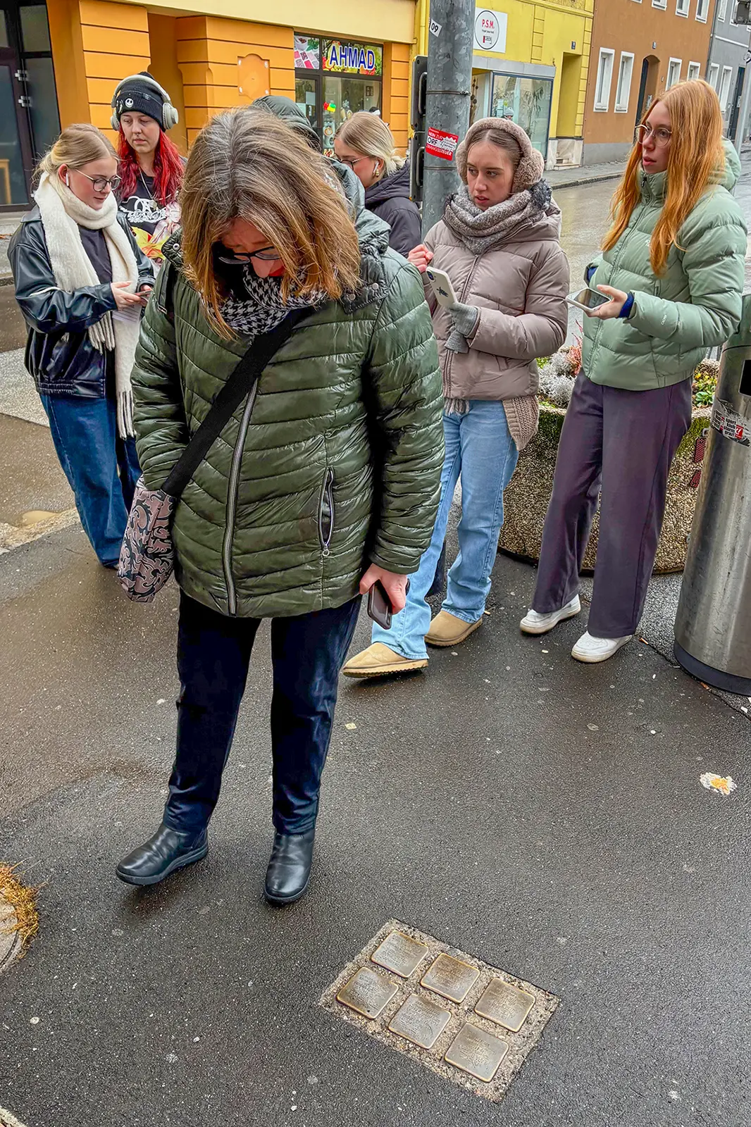 Mehrere Personen betrachten in die Straße eingelassene Gedenksteine