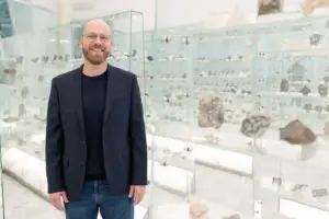 Ein Mann vor einer Vitrine voller Steine.