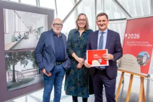 Eine Frau und zwei Männer mit Schautafeln