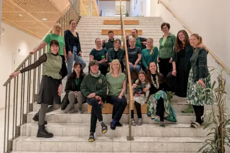 Bunte Woche in Leobener Volksschule Eine Gruppe von Personen in grüner Kleidung auf einer Treppe