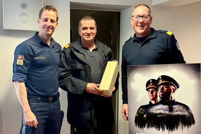 Vernetzung der Einsatzkräfte Drei Männer in Uniform halten ein Plakat