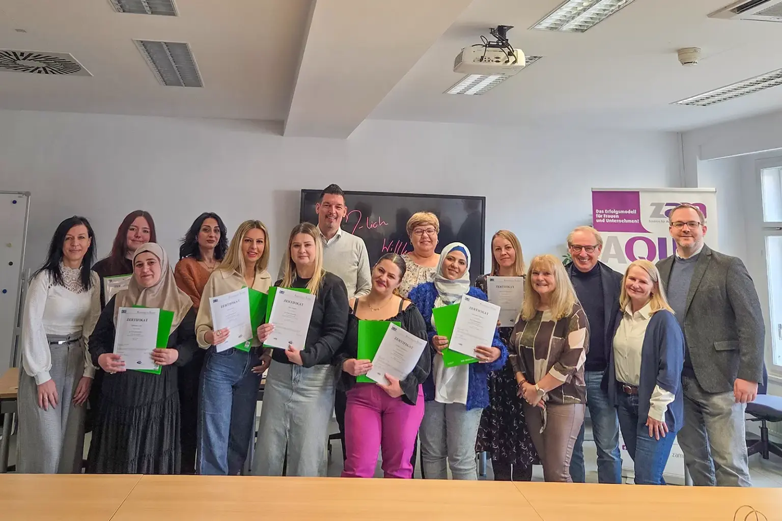 Eine Gruppe von Frauen präsentiert gemeinsam mit drei Männern Urkunden