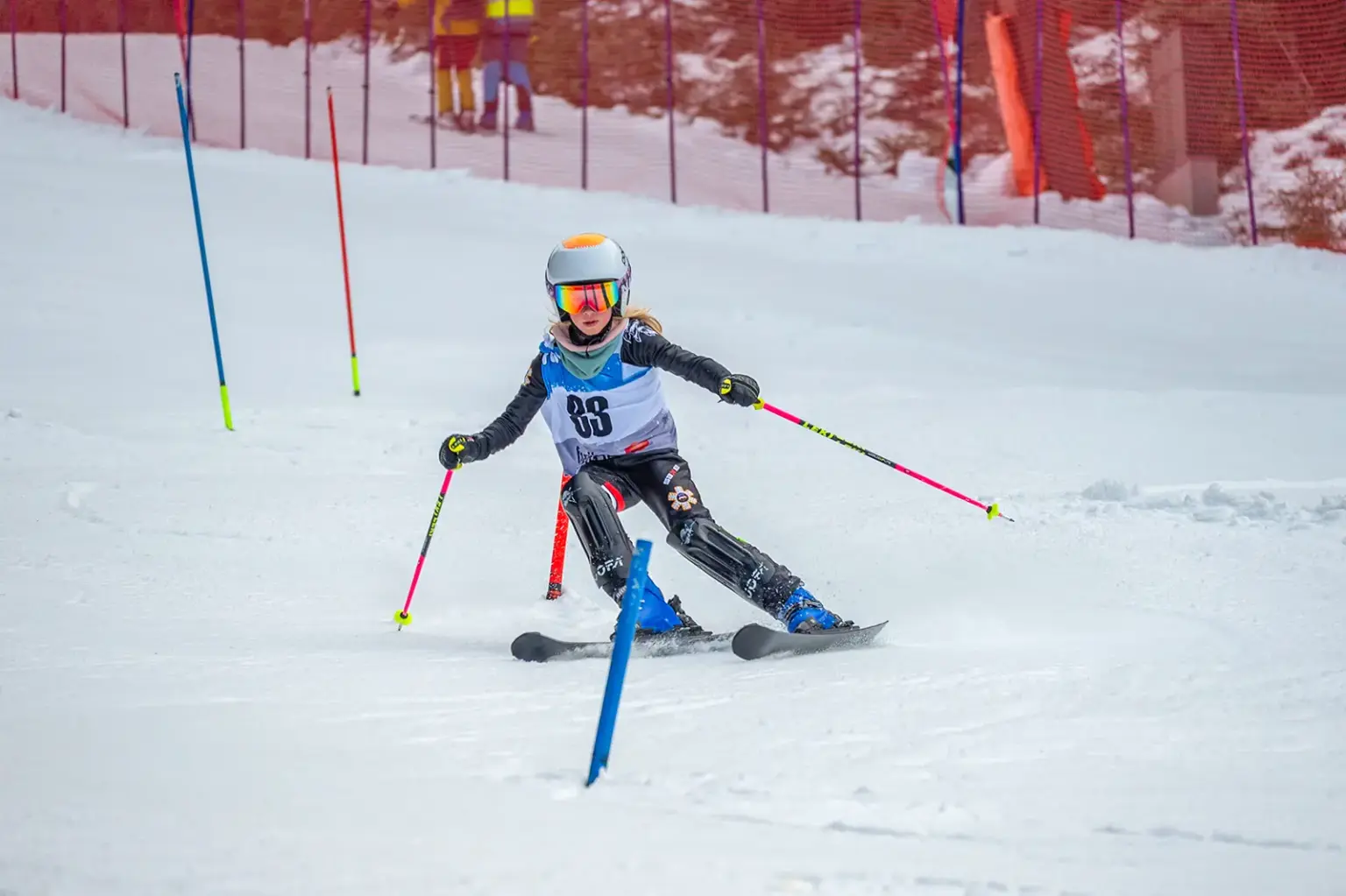 Finale im Schibezirkscup Ein kleines Mädchen auf Schi fährt durch Slalomstangen.
