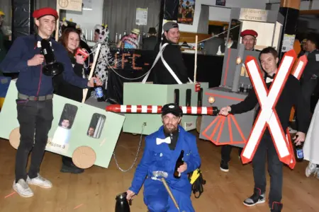 Maskenball mit Prämierung Eine Gruppe von Personen mit einer Lokomotive und Waggons aus Karton