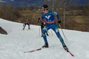 Ein Jugendlicher mit Langlaufski auf einer Loipe. Dahinter sind zwei weitere Jugendliche mit Langlaufski zu erkennen.