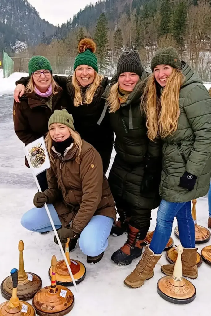 Fünf Frauen mit Eisstöcken auf einer Eisbahn