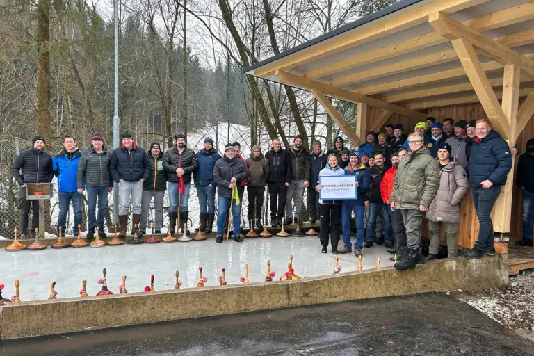Eine Gruppe von Personen vor einer Eisbahn mit Eisstöcken