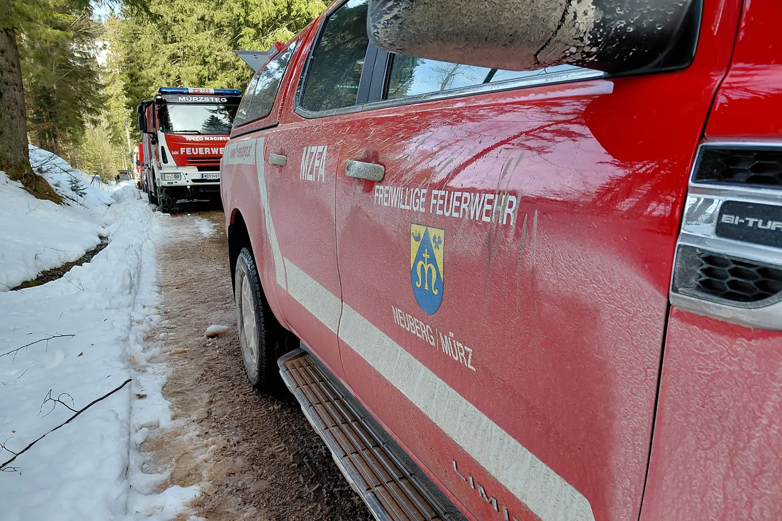 Zwei Feuerwehrfahrzeuge auf einer Forststraße