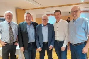 Fünf Männer mit Hemd und Sakko gekleidet stehen nebeneinander.