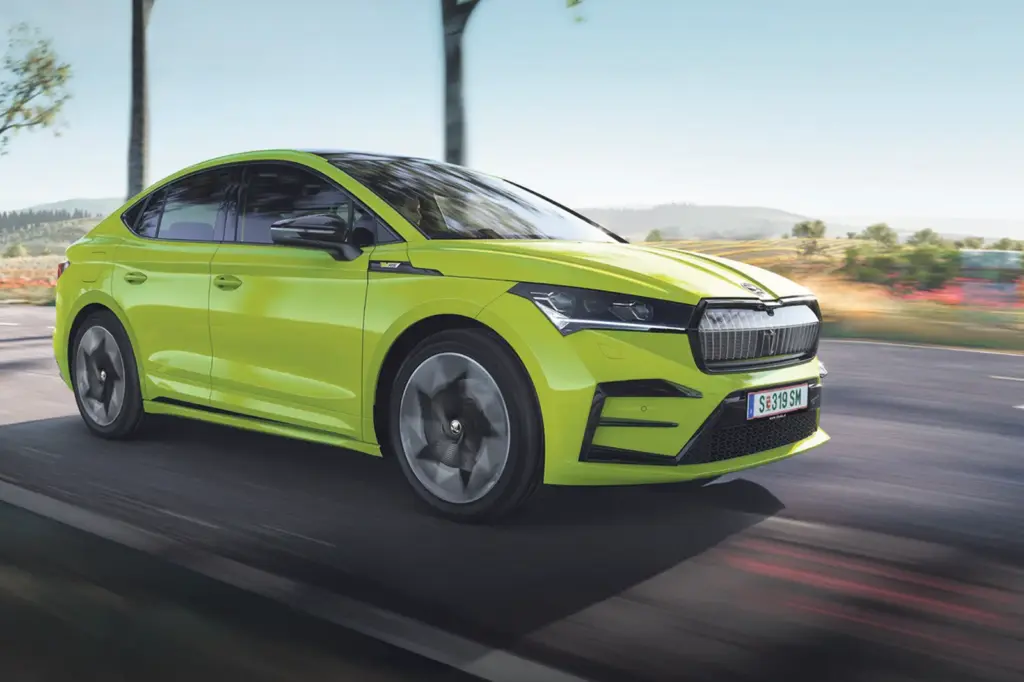 Ein grünes Fahrzeug mit Coupé-Karosserie und Elektroantrieb fährt von links nach rechts