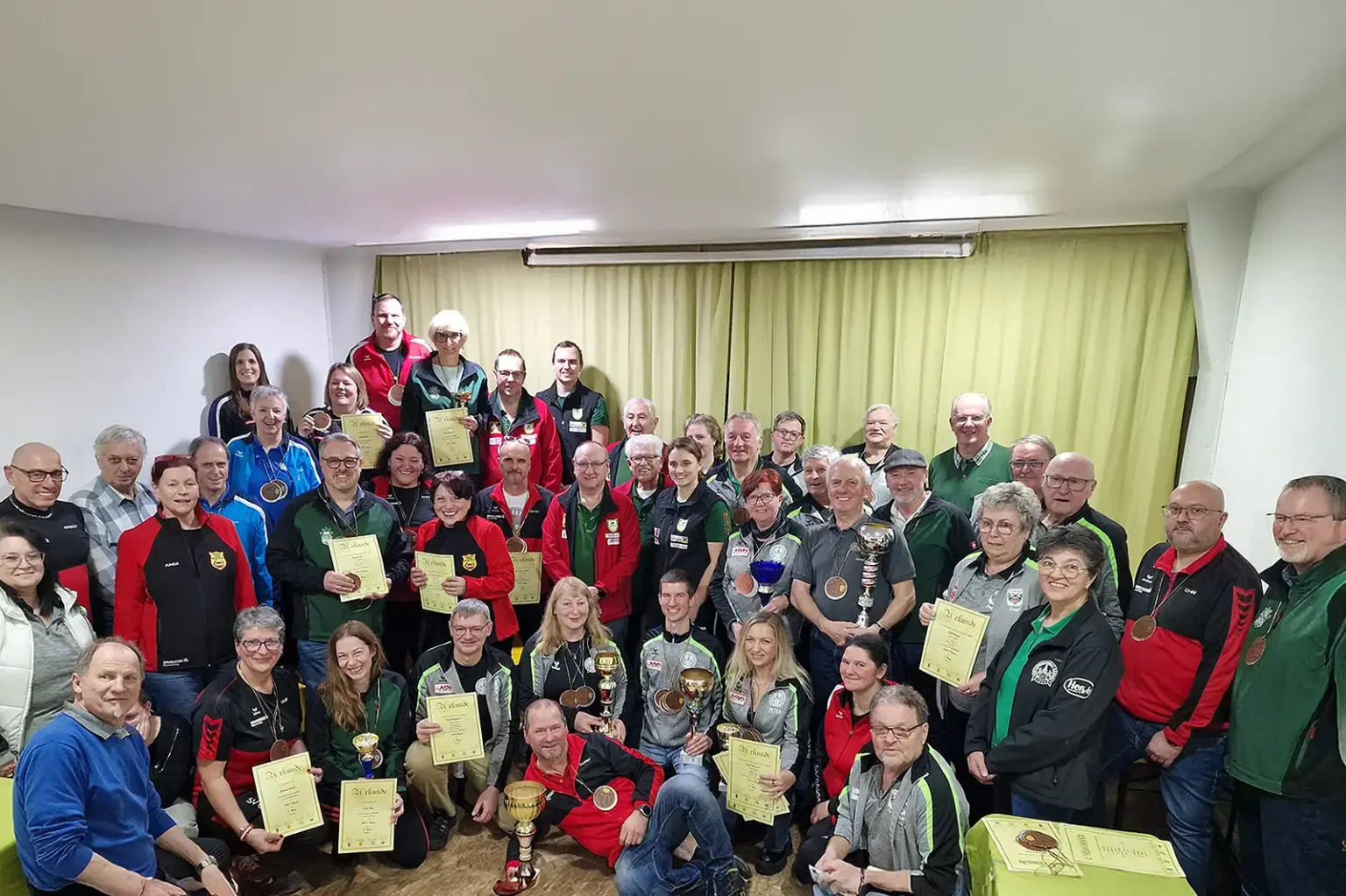 Neuer Teilnehmerrekord beim Obersteiermark-Cup Zahlreiche Menschen in einem Raum mit Pokal und Medaillen.