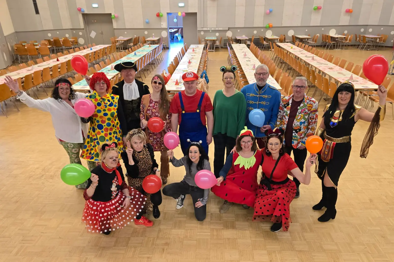 Eine Gruppe von kostümierten Personen in einem leeren Veranstaltungssaal