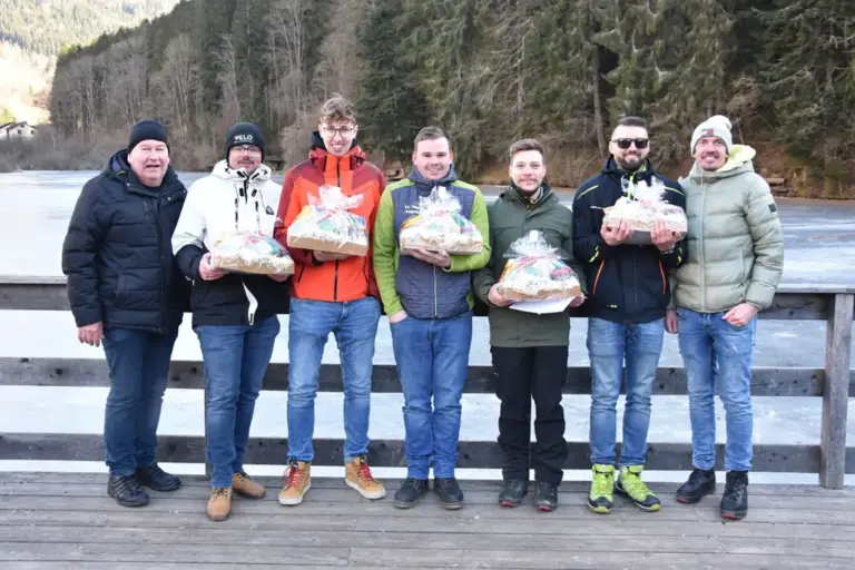 Sieben Männer mit Geschenkskörben auf einem Steg über einer Eisfläche