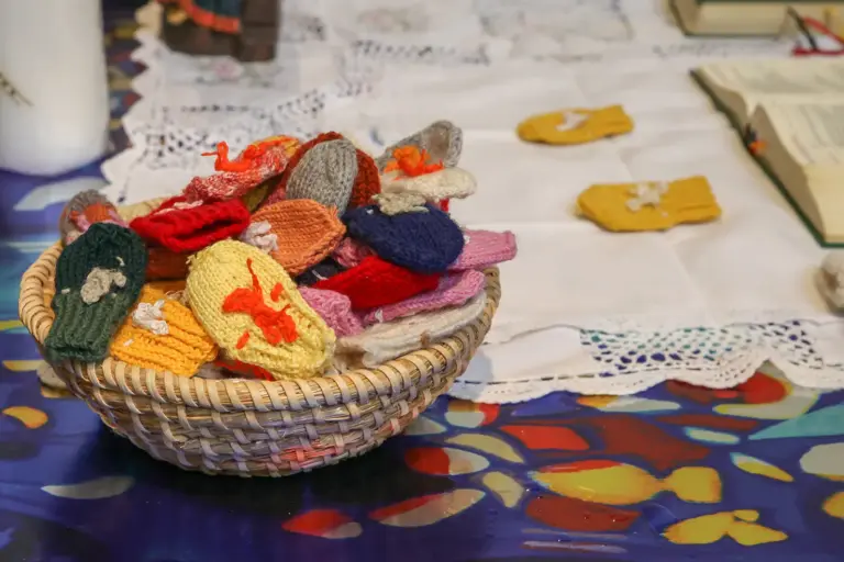 Handschuhtragen – das Z’ruckbringen Ein Körbchen voller kleiner gestrickter Fäustlinge