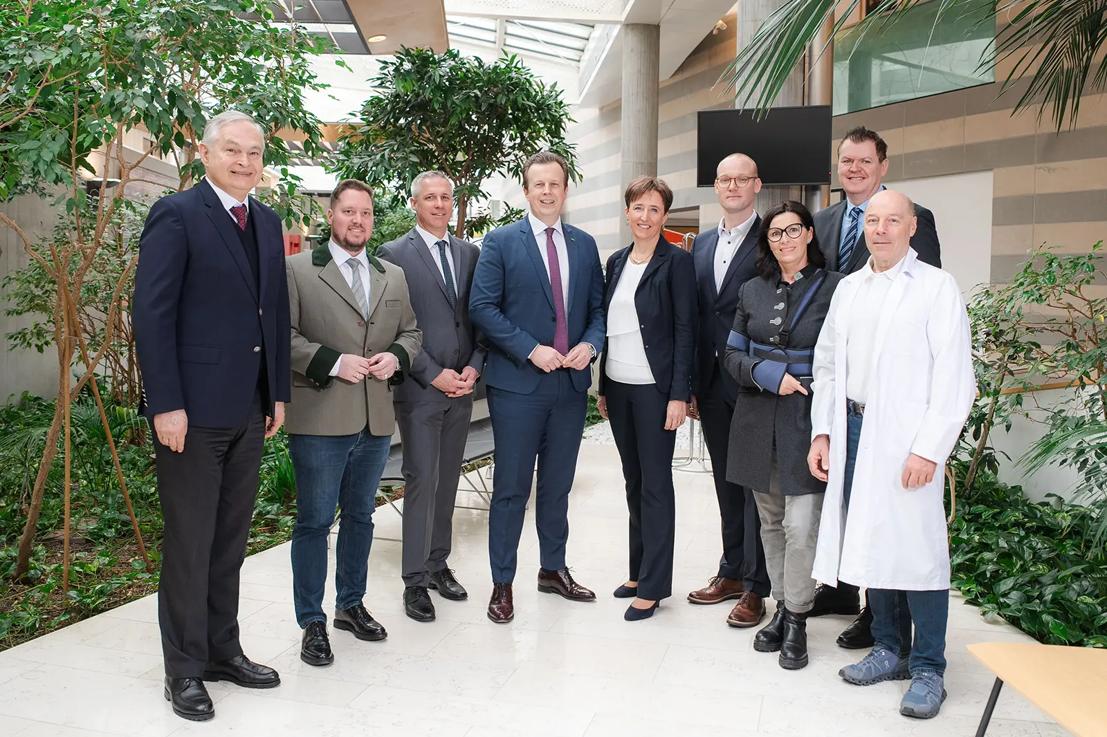 Mehrere Menschen stehen nebeneinander und lächeln in Richtung Kamera.