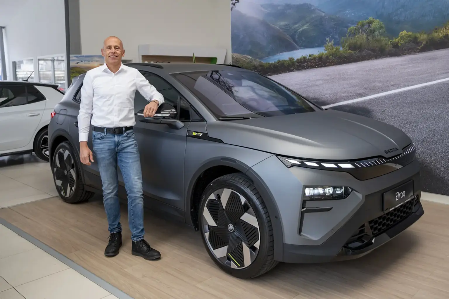 Ein Mann steht neben einem Auto.