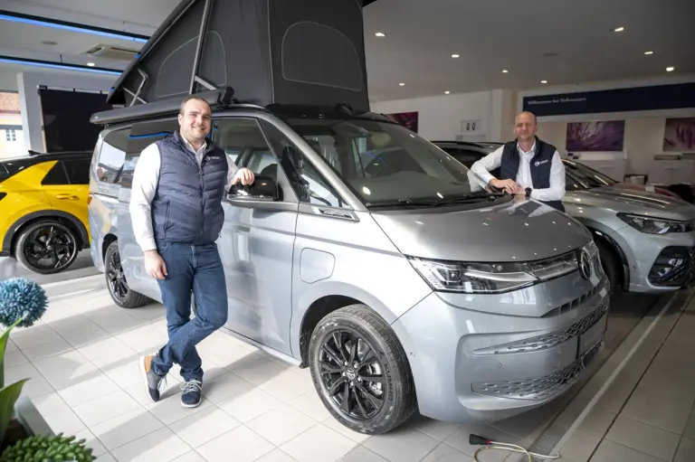 Zwei Männer stehen neben einem Auto.