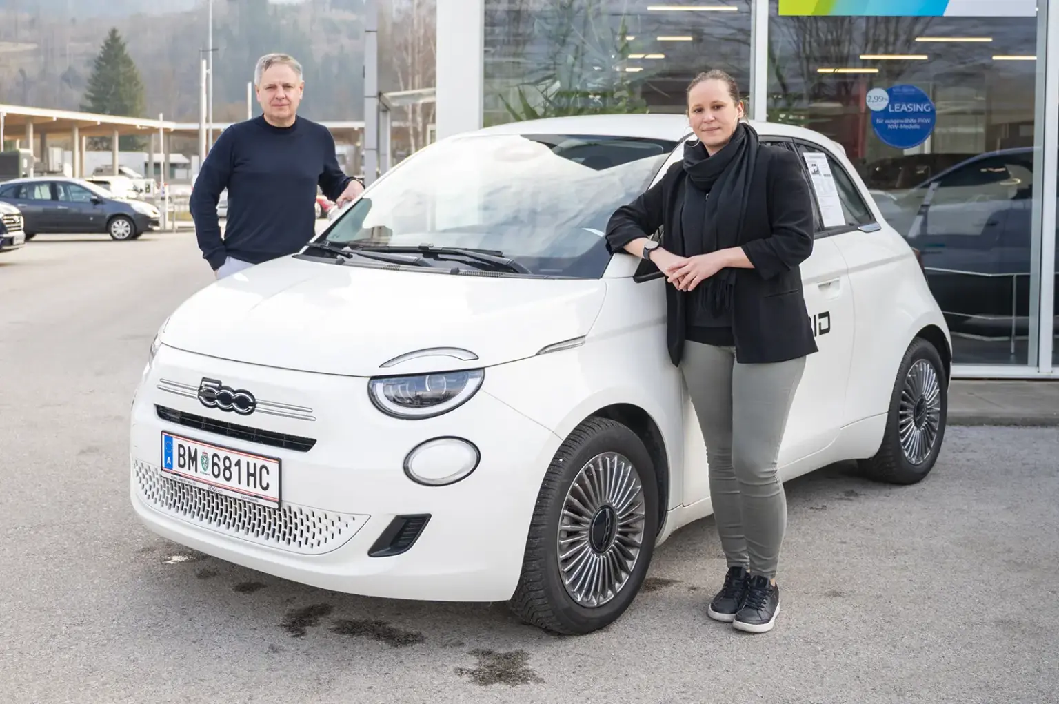 Eine Frau und ein Mann neben einem Auto.