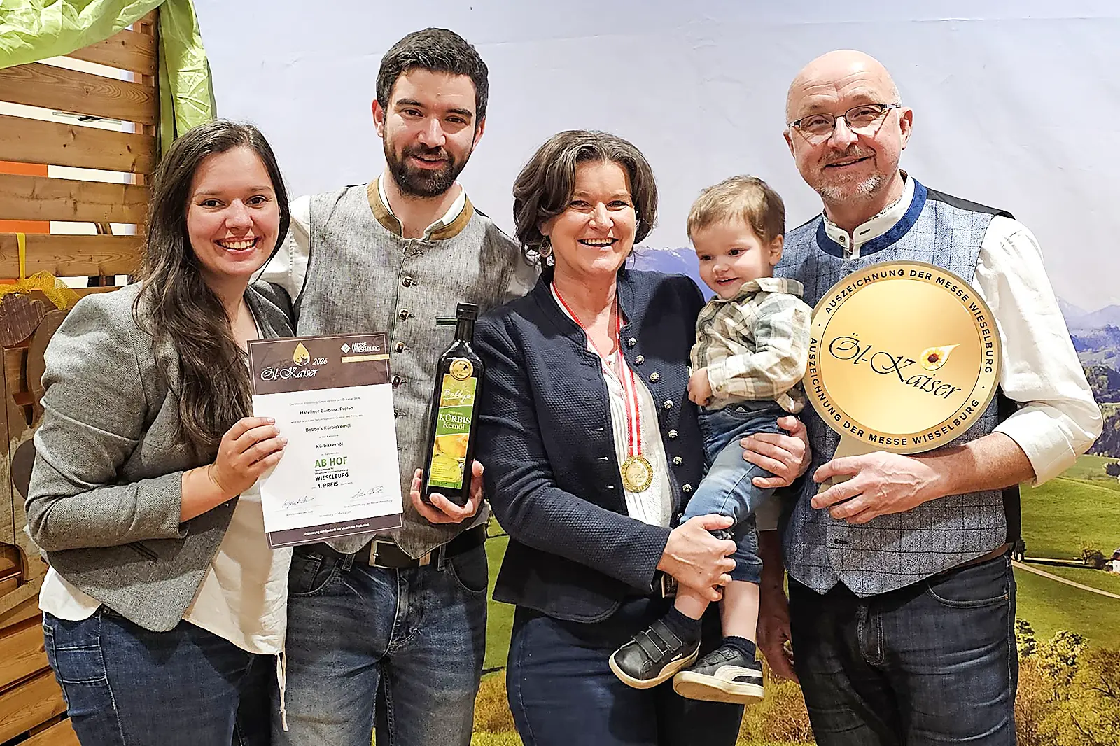 Eine Familie in Tracht präsentiert Preise und Medaillen