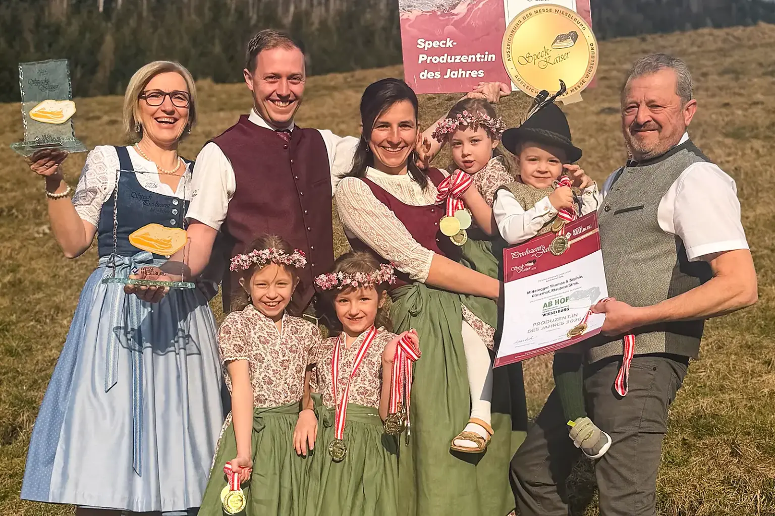 Ab Hof Messe: Regionale Anbieter räumten ab Eine Familie in Tracht präsentiert Preise und Medaillen