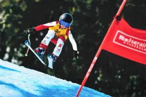 Heimischer Schinachwuchs zeigte beim steirischen Kindercup auf Ein Bub springt mit den Schi und fährt auf ein rotes Tor zu.