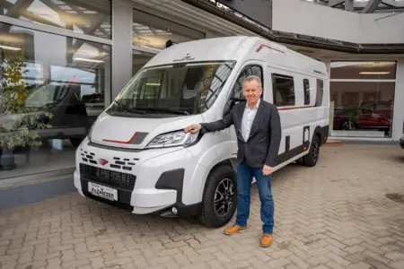 XL im Kasten Ein Mann steht neben einem Auto.