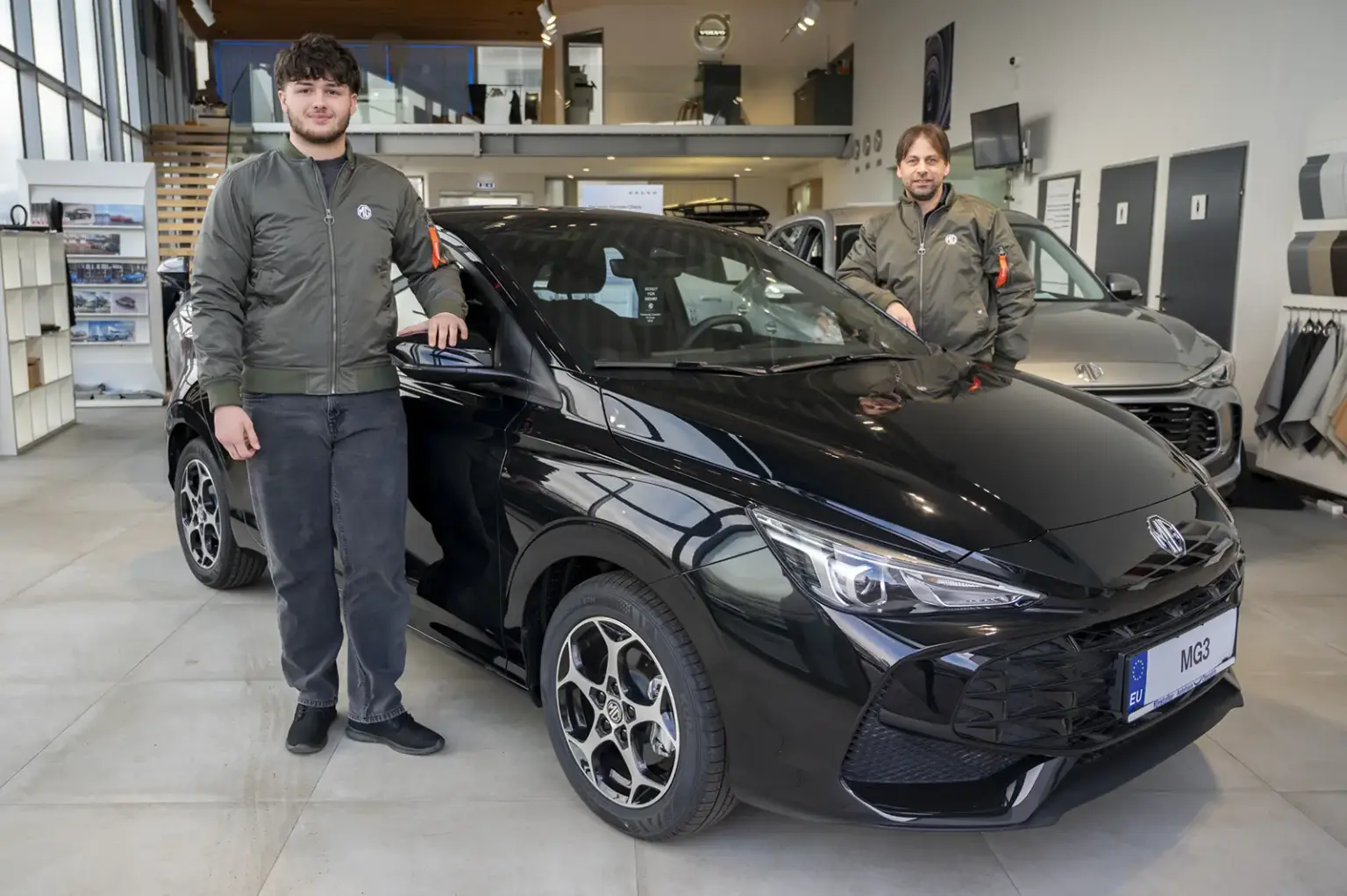 Zwei Männer stehen neben einem Auto.