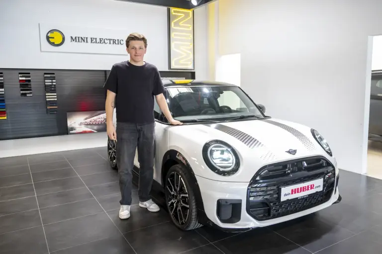 Ein Mann steht neben einem Auto.