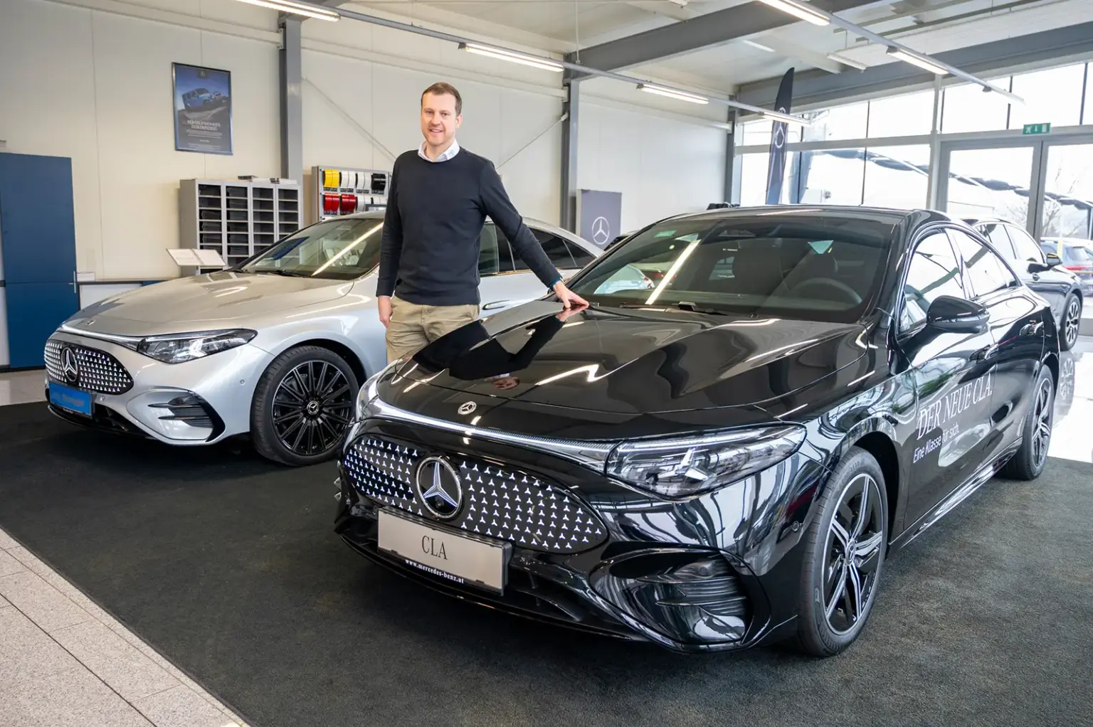 Ein Mann steht zwischen zwei Autos.