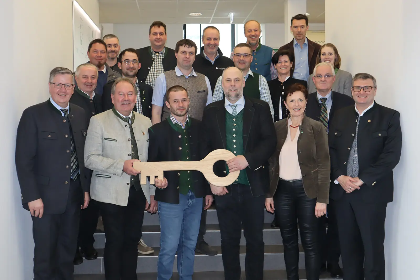 Eine Gruppe von Personen auf einer Treppe mit einem großen Schlüssel