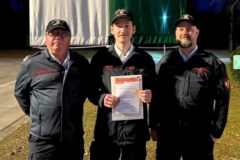 Drei Männer in Uniform präsentieren eine Urkunde