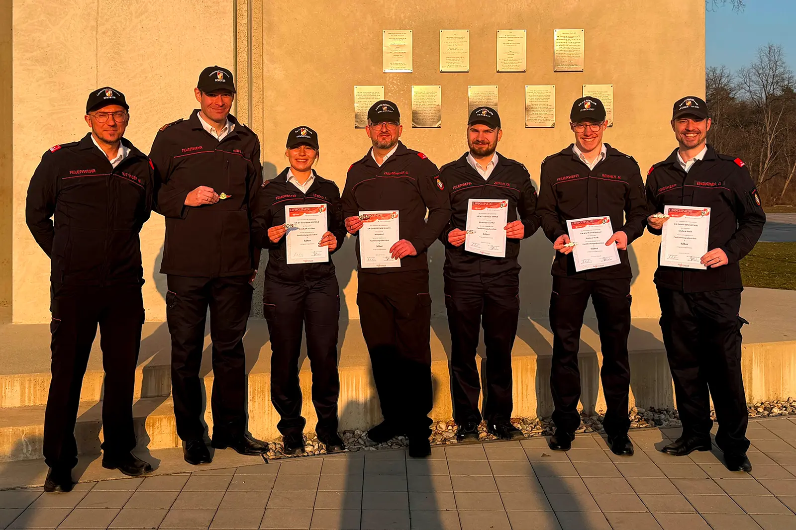 Sieben Personen in Uniform präsentieren Urkunden