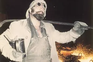 Ein Mann in alter Schutzkleidung in einer Fabrik